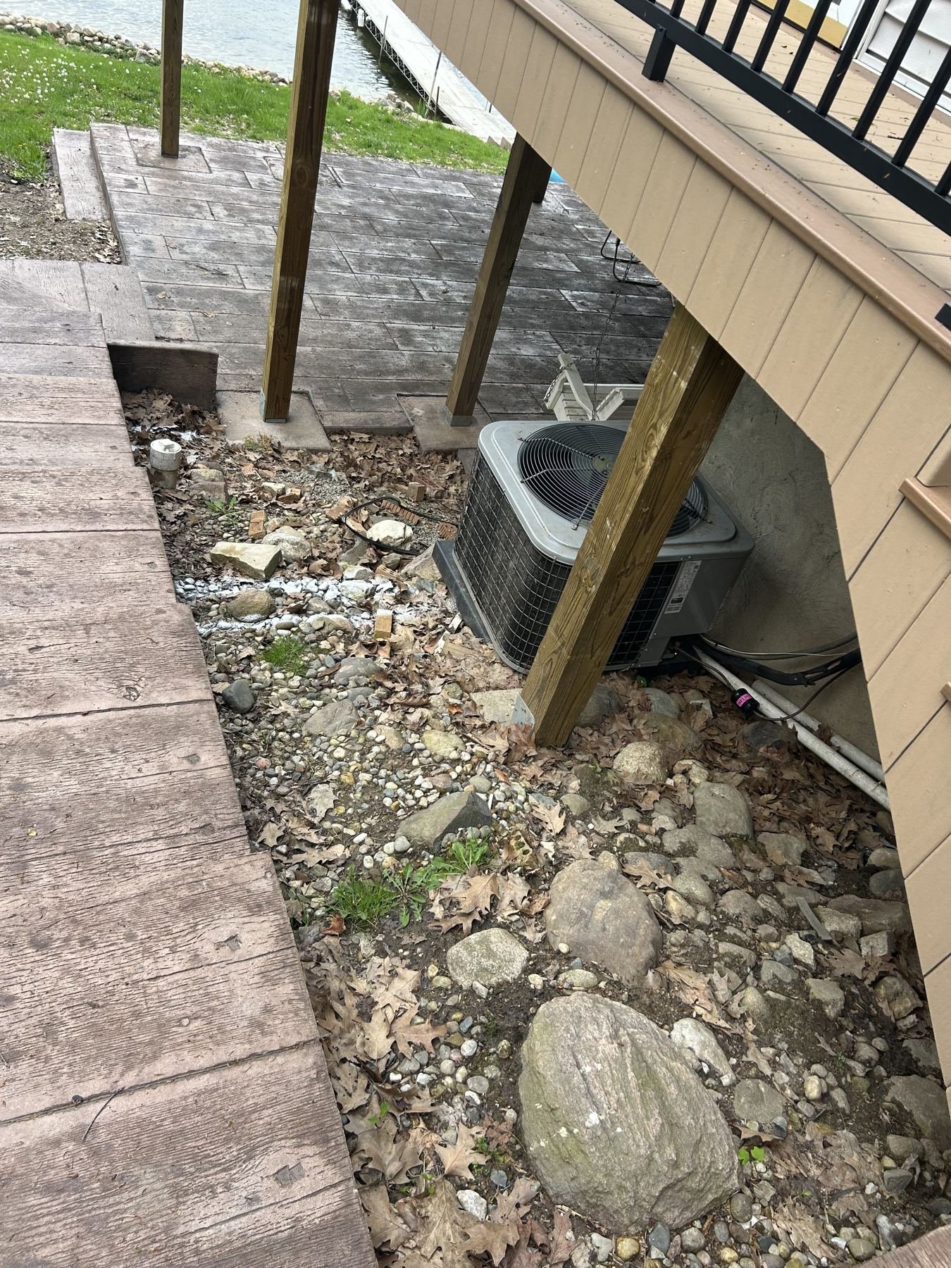 Stamped concrete patio installed beneath an elevated deck