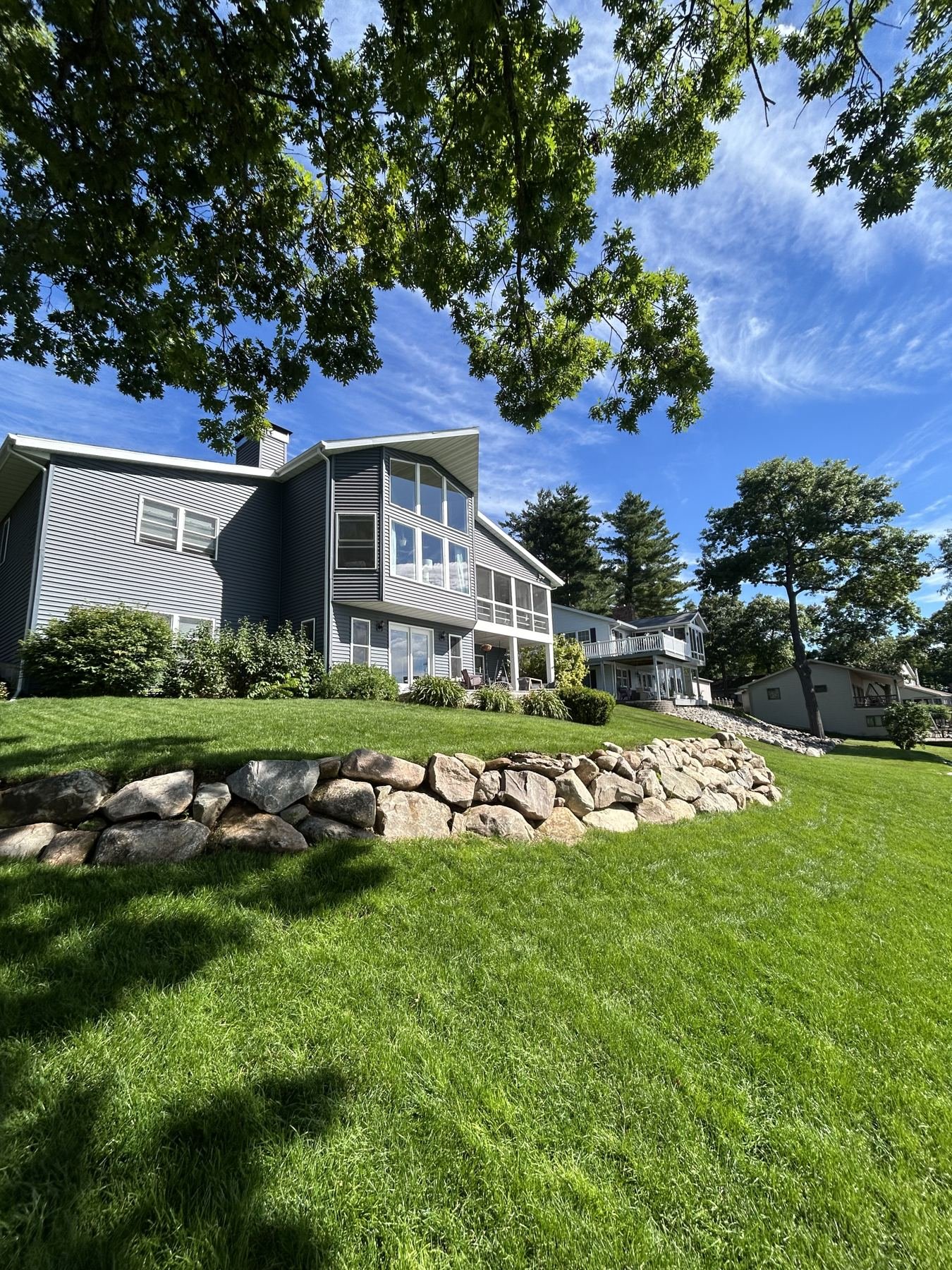 Natural boulder retaining wall holding a lawn terrace